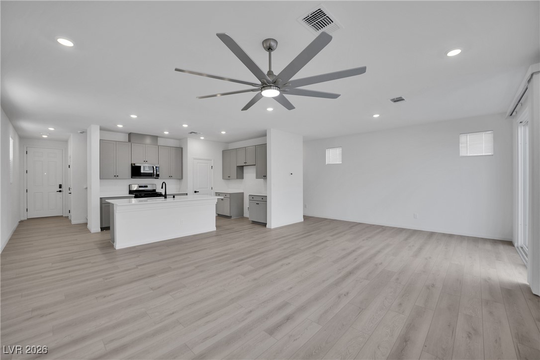 9136 Rivington Avenue Las Vegas, NV 89148 - Photo 43 of 43 Kitchen featuring gray cabinetry, open floor plan, light countertops, recessed lighting, and a kitchen island with sink