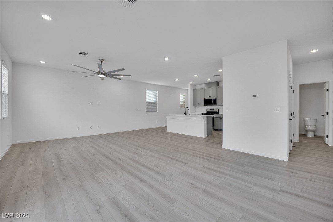 9136 Rivington Avenue Las Vegas, NV 89148 - Photo 4 of 43 Unfurnished living room with recessed lighting, light wood-style floors, and a ceiling fan