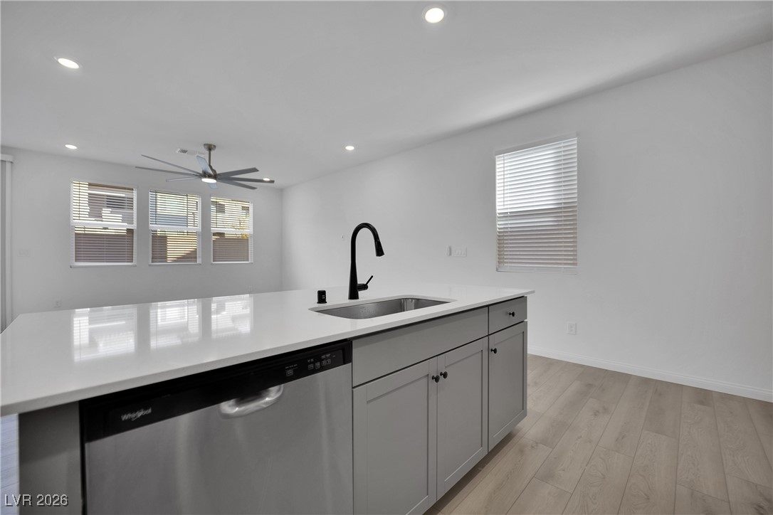 9136 Rivington Avenue Las Vegas, NV 89148 - Photo 7 of 43 Kitchen with stainless steel dishwasher, light wood-style floors, gray cabinetry, recessed lighting, and ceiling fan