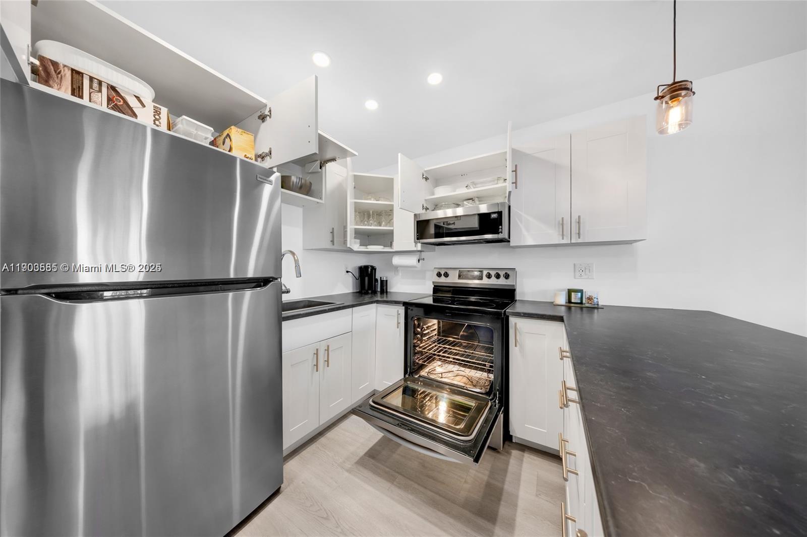 15610 Northeast 6th Avenue, Unit 33D Miami, FL 33162 - Photo 12 of 18 a kitchen with stainless steel appliances a refrigerator sink and microwave