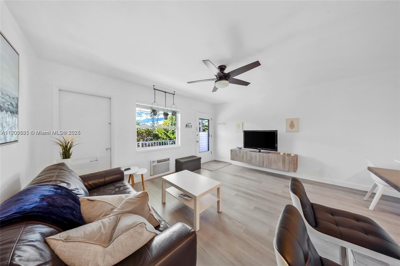 15610 Northeast 6th Avenue, Unit 33D Miami, FL 33162 - Photo 8 of 18 a living room with furniture and a flat screen tv