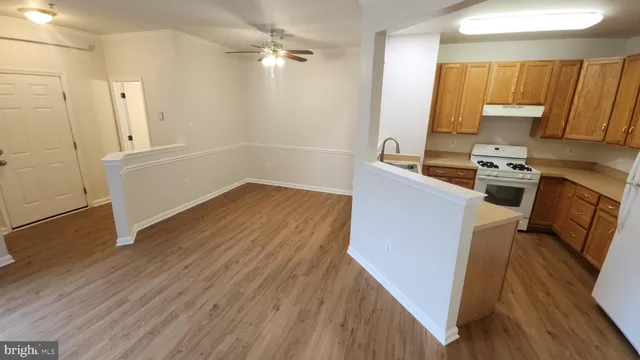 a kitchen with wooden floors and refrigerator