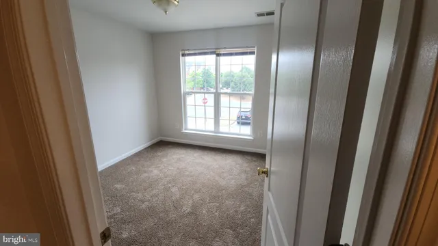 a view of an empty room with windows and closet