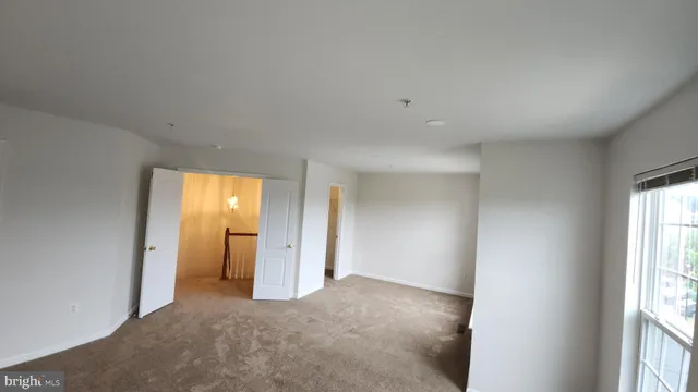 an empty room with a window and a bathroom