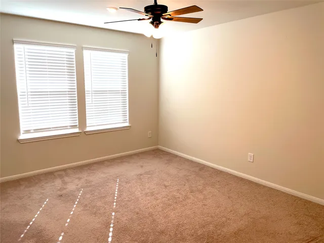 a view of a room with a window and a ceiling fan