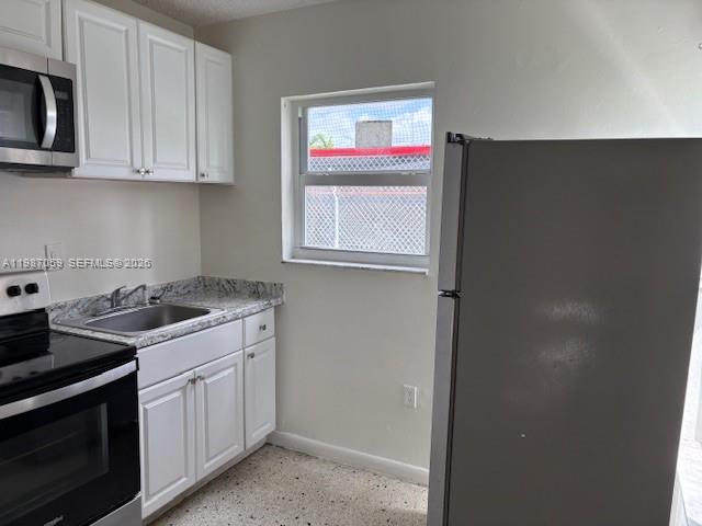 828 Southwest 20th Avenue, Unit 1 Miami, FL 33135 - Photo 2 of 10 a kitchen with stainless steel appliances granite countertop a stove and a microwave