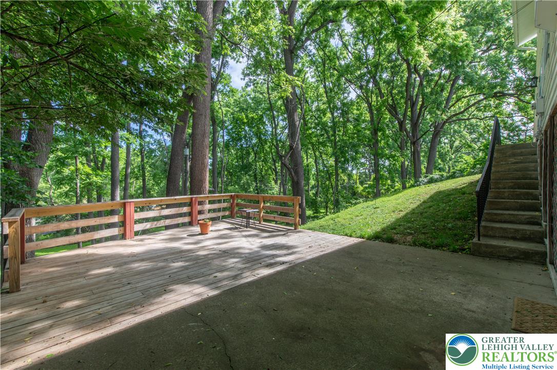 2011 Greenwood Road Allentown, PA 18103 - Photo 45 of 52 A spacious wooden deck extends into a verdant, tree-lined landscape.