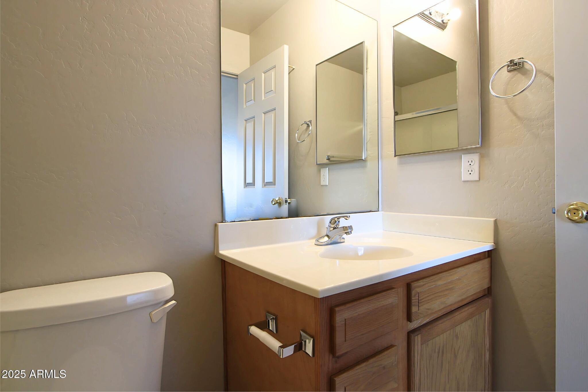 13211 South Kin Circle, Unit C Arizona City, AZ 85123 - Photo 10 of 17 a bathroom with a sink a toilet and mirror
