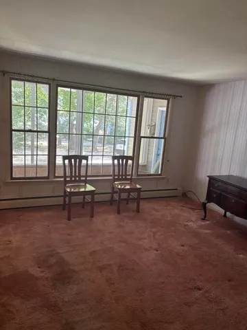 a living room with furniture and a floor to ceiling window