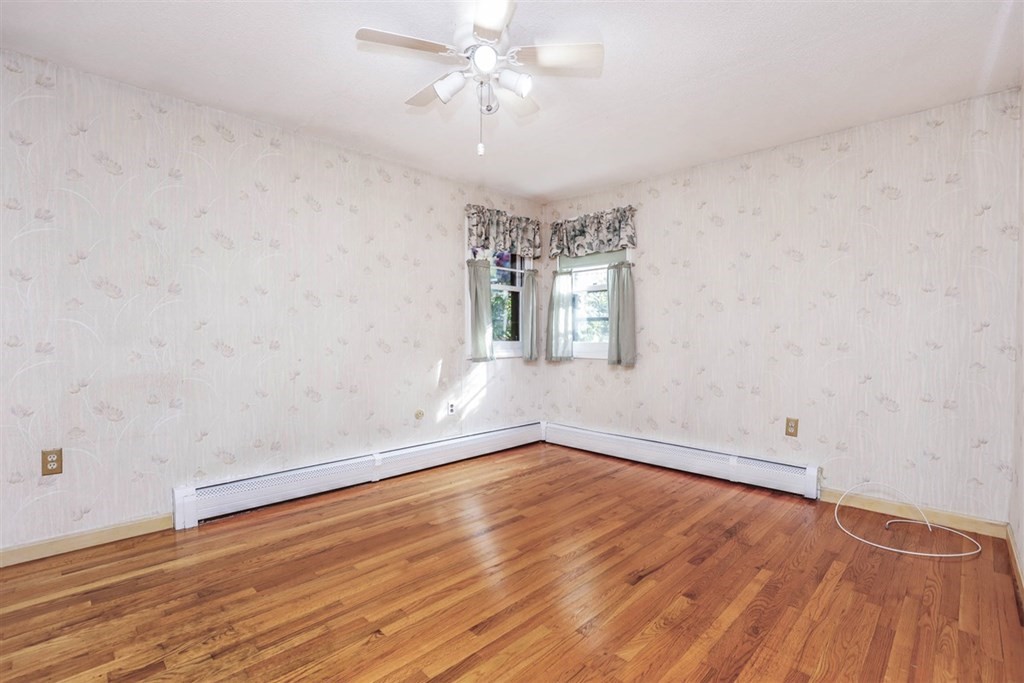 120 Chadwick Road Haverhill, MA 01835 - Photo 17 of 29 an empty room with wooden floor chandelier fan and windows