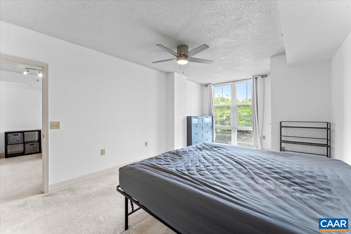 11760 Sunrise Valley Drive, Unit 208 Reston, VA 20191 - Photo 12 of 30 a bedroom with a bed and a ceiling fan