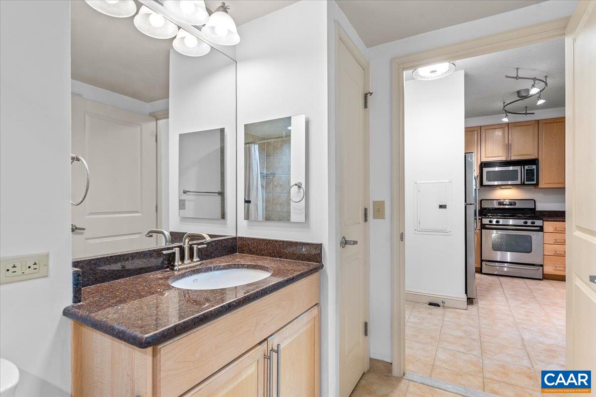11760 Sunrise Valley Drive, Unit 208 Reston, VA 20191 - Photo 14 of 30 a kitchen with granite countertop a sink cabinets and stainless steel appliances