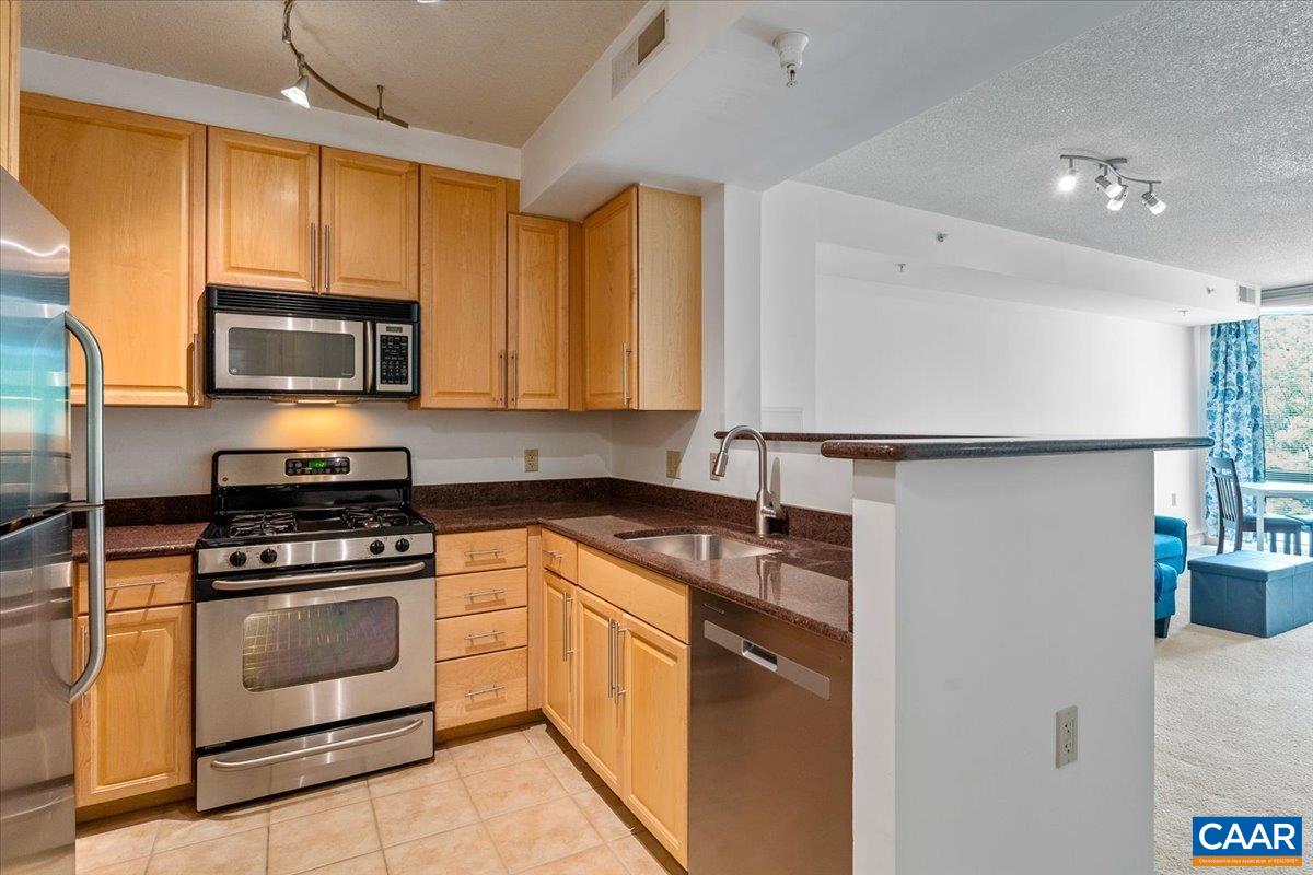 11760 Sunrise Valley Drive, Unit 208 Reston, VA 20191 - Photo 9 of 30 a kitchen with stainless steel appliances granite countertop a stove a refrigerator and a microwave