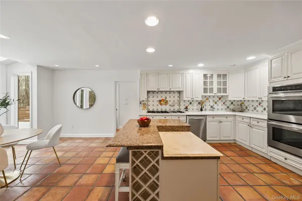 a kitchen with stainless steel appliances granite countertop a stove a sink a microwave and a refrigerator