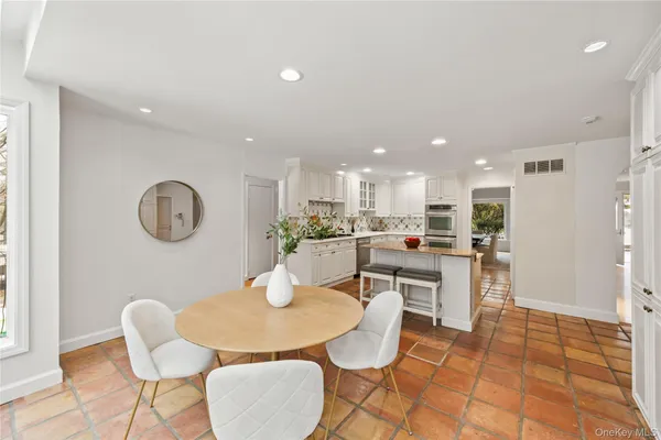 a kitchen with a dining table chairs and view of living room