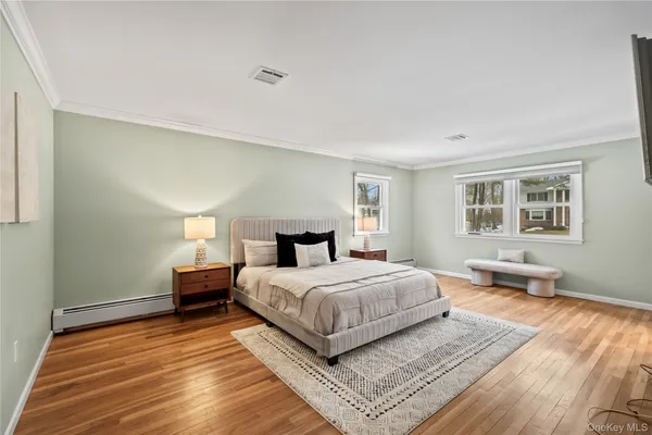 a bedroom with a bed wooden floor and window