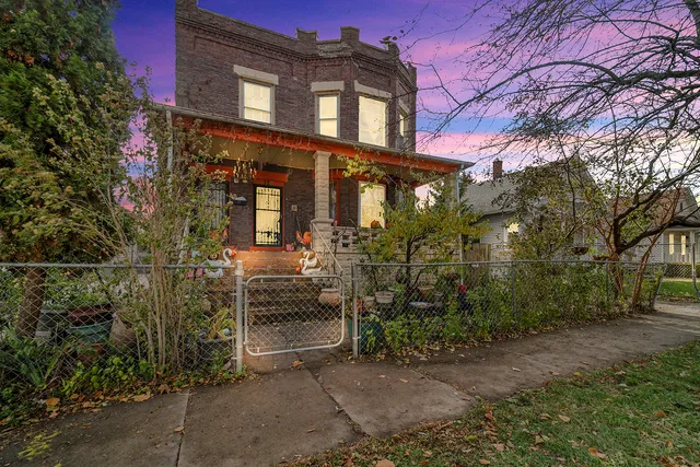front view of a brick house with a yard
