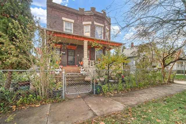 front view of a brick house with a large tree