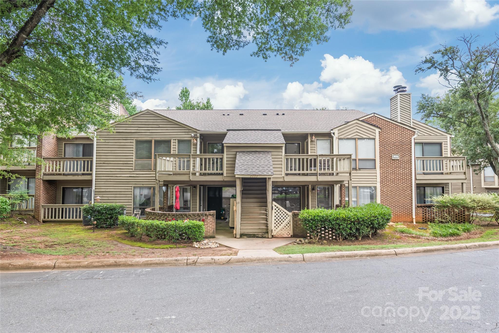 1612 Sharon Road West, Unit 70 Charlotte, NC 28210 - Photo 1 of 18 a front view of a house with a garden