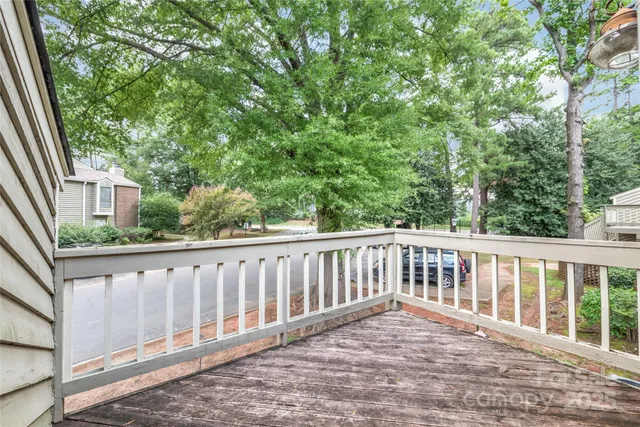 a balcony with wooden floor and fence
