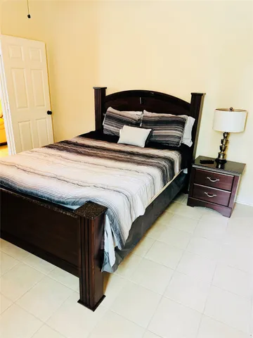 a bedroom with a bed and a lamp on table