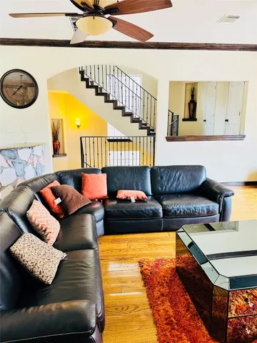 a living room with furniture and a wooden floor