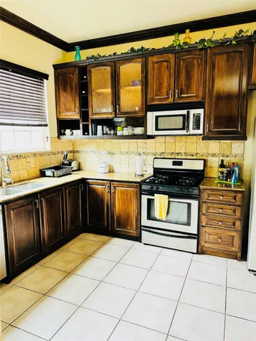 a kitchen with stainless steel appliances granite countertop a stove and a microwave