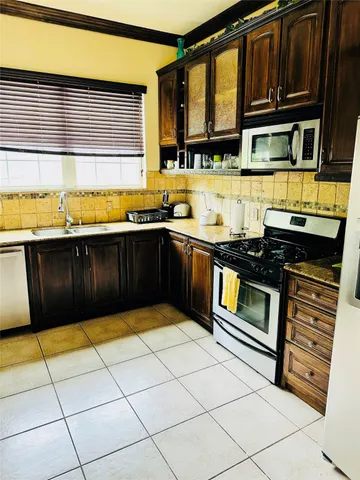 a kitchen with stainless steel appliances granite countertop a stove a sink and a microwave