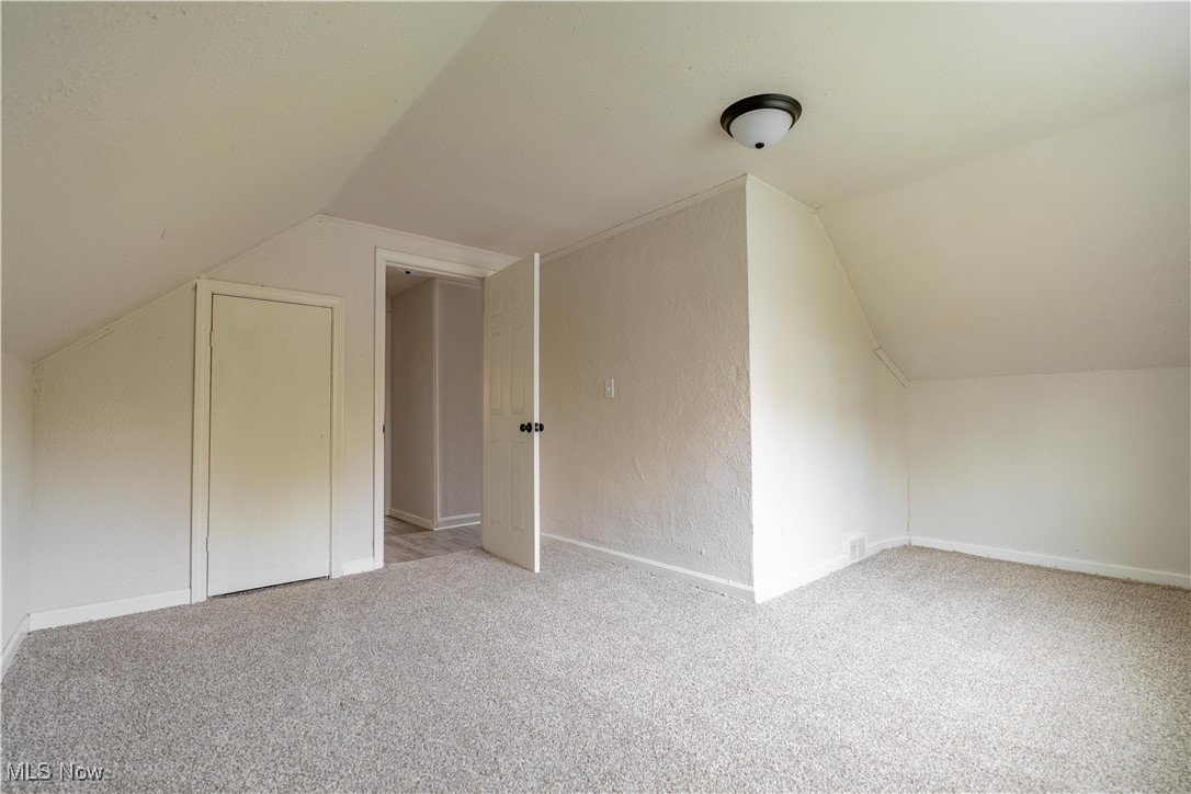 1931 Bridger Road Akron, OH 44312 - Photo 35 of 40 Additional living space with lofted ceiling and light colored carpet
