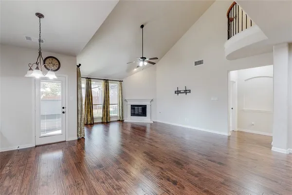 a view of a room with wooden floor fireplace and windows