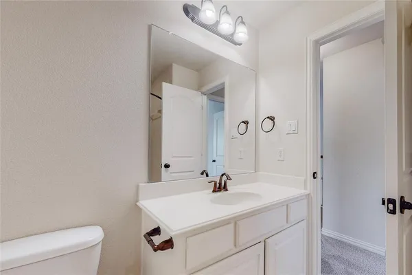 a bathroom with a sink a toilet and a mirror