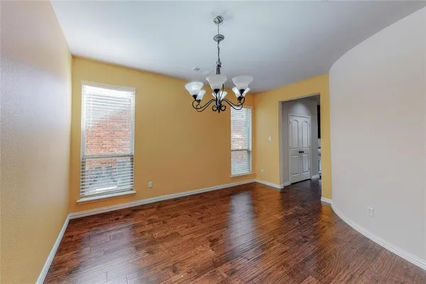 a view of a room with wooden floor and chandelier