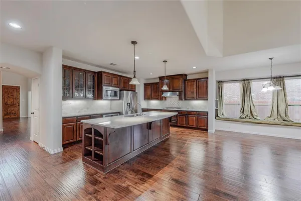 a kitchen with stainless steel appliances granite countertop a stove and a wooden floors