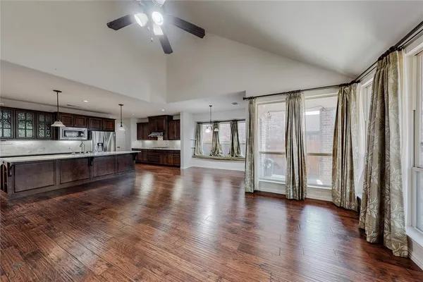a view of a kitchen with a large window wooden floor and a refrigerator
