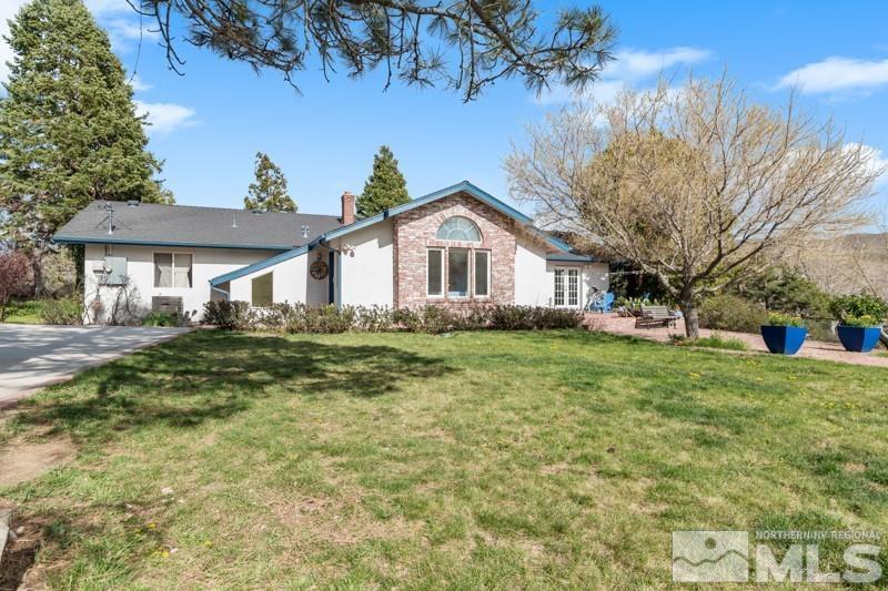 21025 Ames Lane Reno, NV 89521 - Photo 3 of 34 a front view of a house with a garden