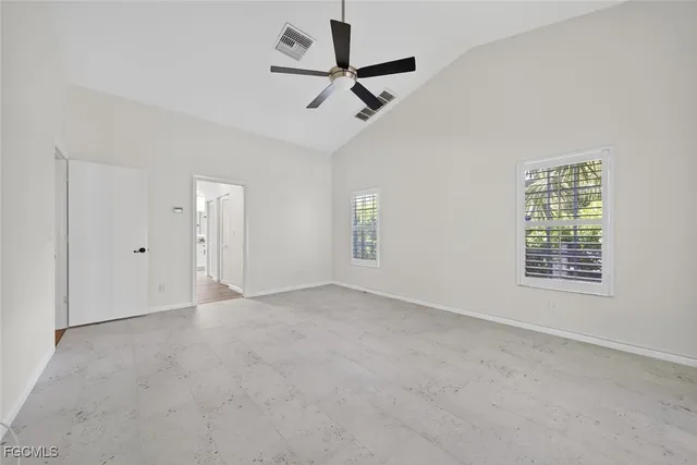 an empty room with a window and a ceiling fan