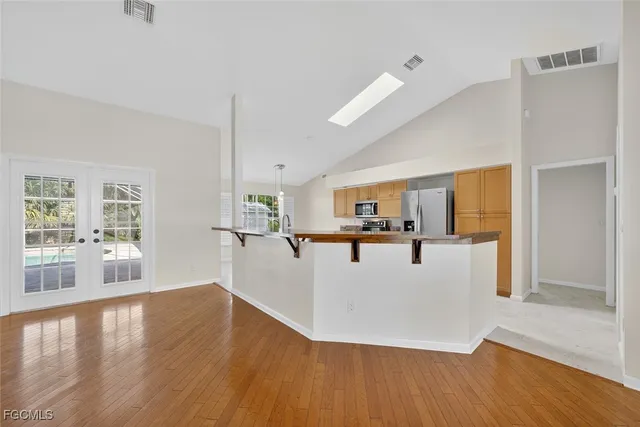a view of a living room a kitchen and a wooden floor