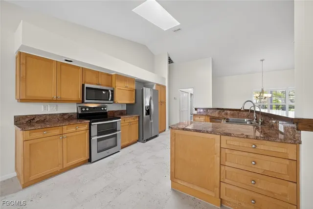 a kitchen with stainless steel appliances granite countertop a sink and dishwasher a stove top oven with wooden floor