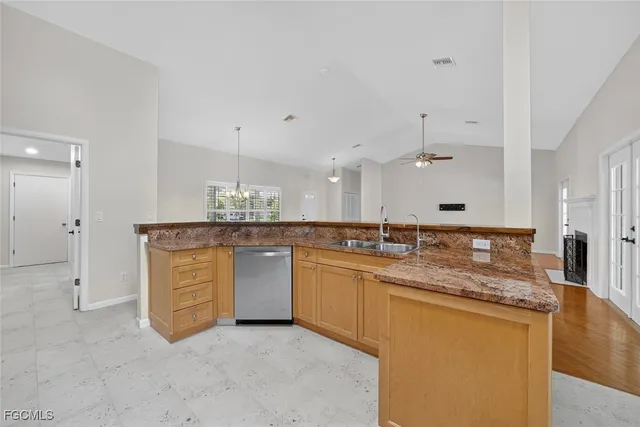 a kitchen with granite countertop a sink and white cabinets