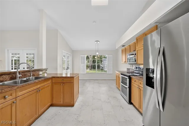 a kitchen with granite countertop a sink stove and refrigerator