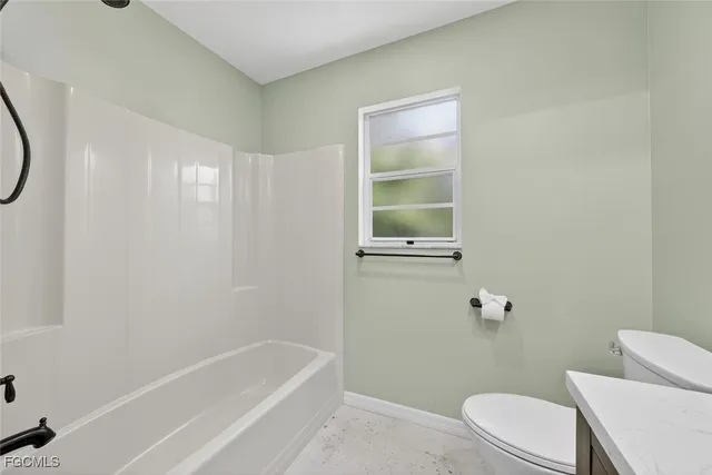a white toilet sitting next to a bath tub