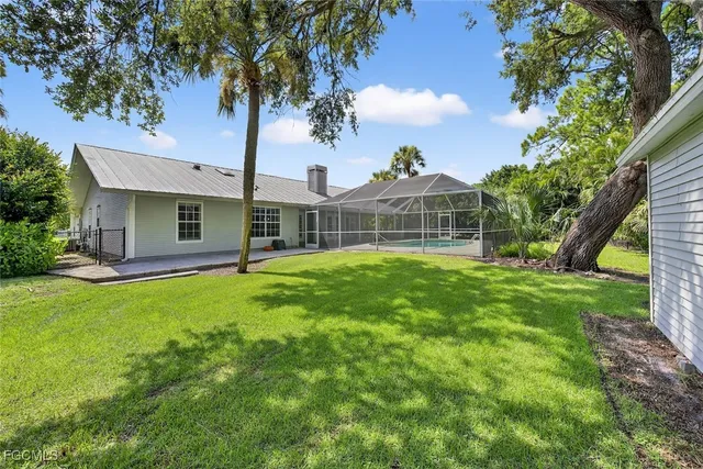 a view of a house with backyard and a tree