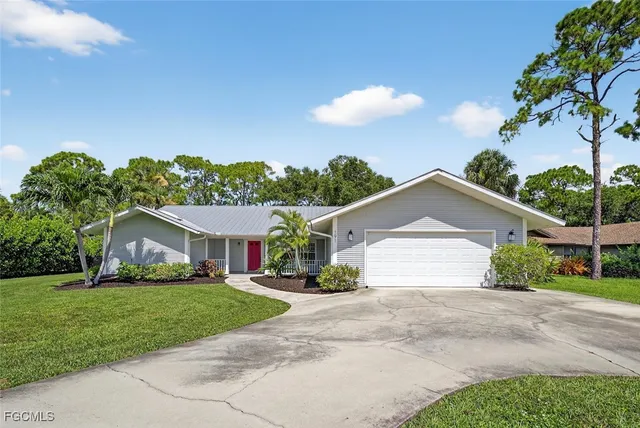 a front view of a house with a yard and potted plants