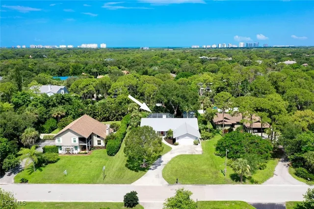 an aerial view of residential houses with outdoor space and trees