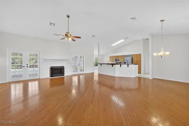 a view of empty room with wooden floor and fireplace