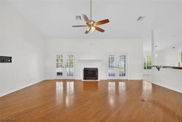a view of empty room with kitchen and fireplace