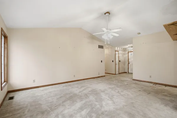 an empty room with a ceiling fan and a window