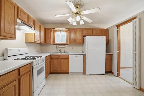 a kitchen with white cabinets and white appliances