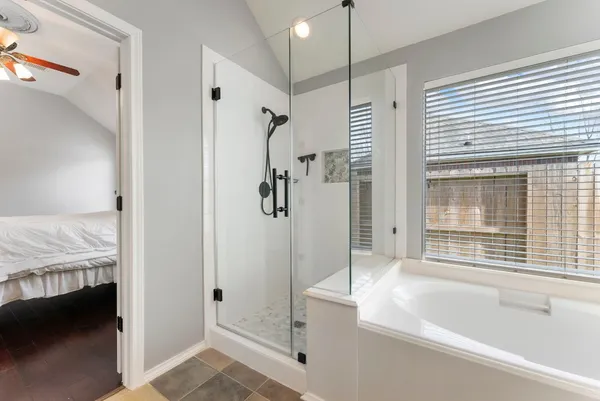 a bathroom with a tub shower and sink