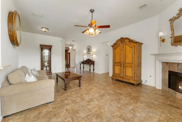 a living room with furniture a fireplace and a chandelier